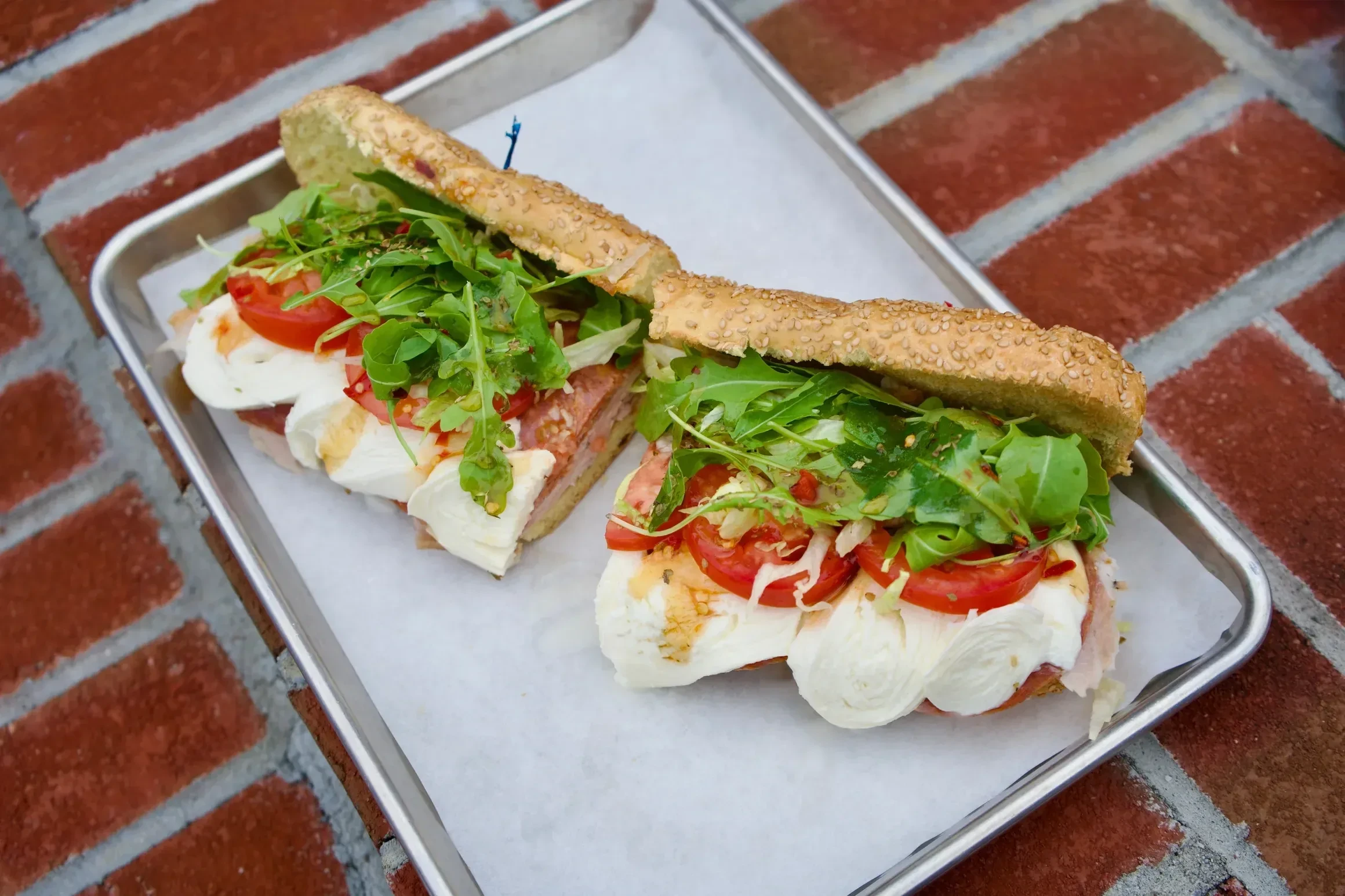 A generously layered Italian panini with fresh mozzarella, tomato and arugula