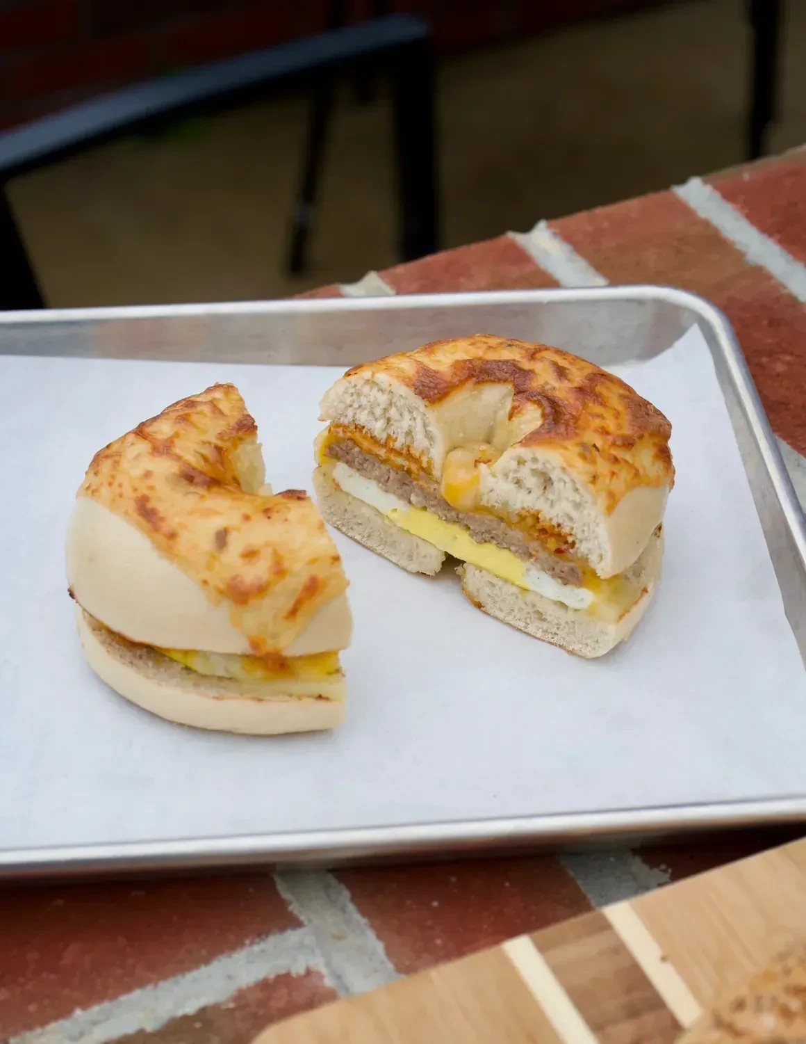 A breakfast bagel sandwich cut open to show the egg and melted cheese